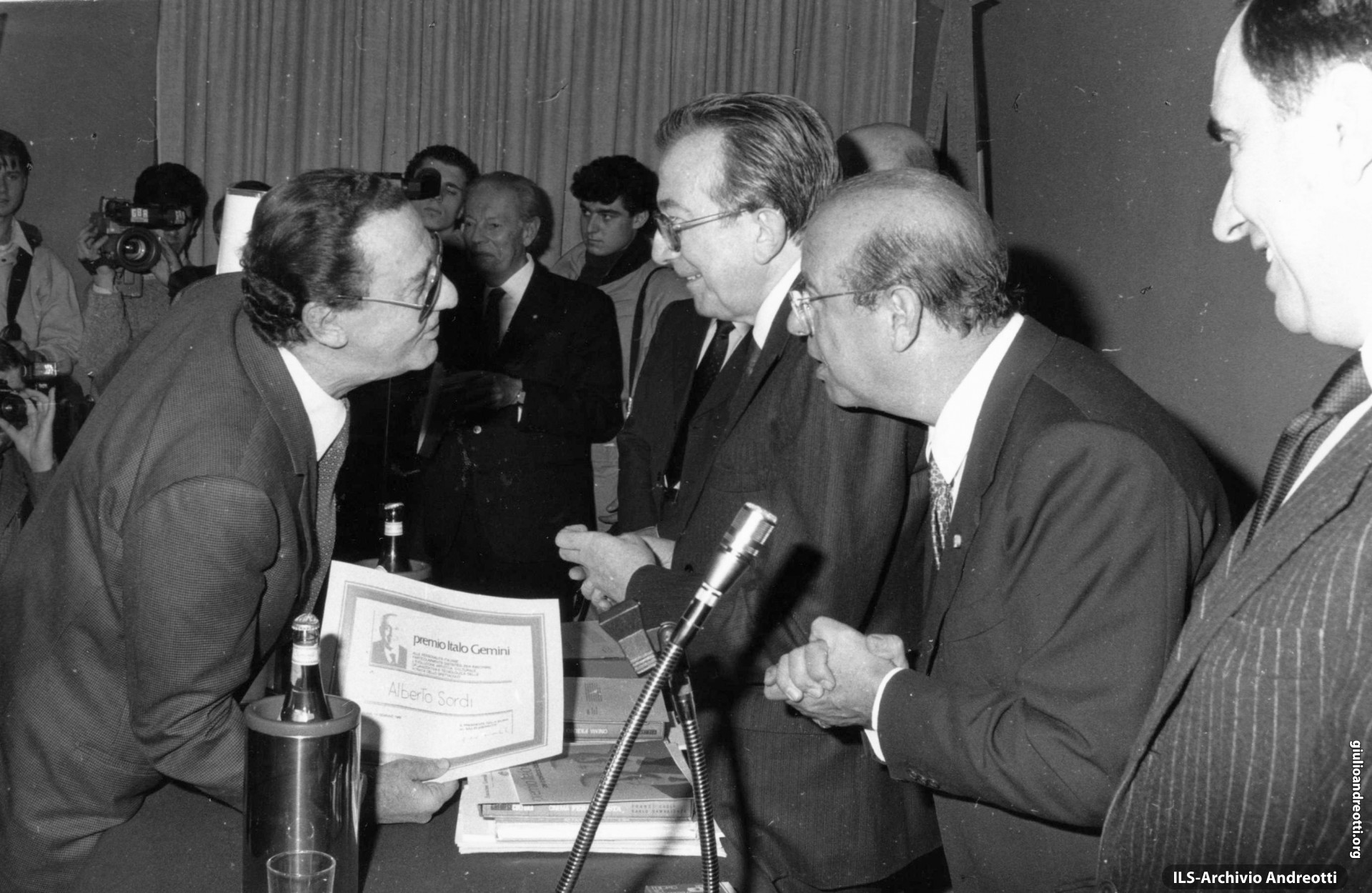 Gennaio 1989. Alberto Sordi riceve da Giulio Andreotti, Presidente del Consiglio, e da Paolo Bruno, Presidente dell’Agis, il Premio cinematografico “Italo Gemini” 