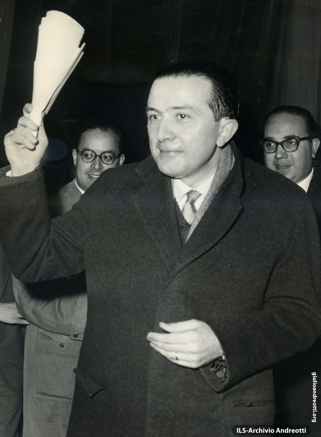3 marzo 1958. Discorso al teatro Adriano. Alle sue spalle due esponenti della DC romana Nicola Signarello e Amerigo Petrucci.
