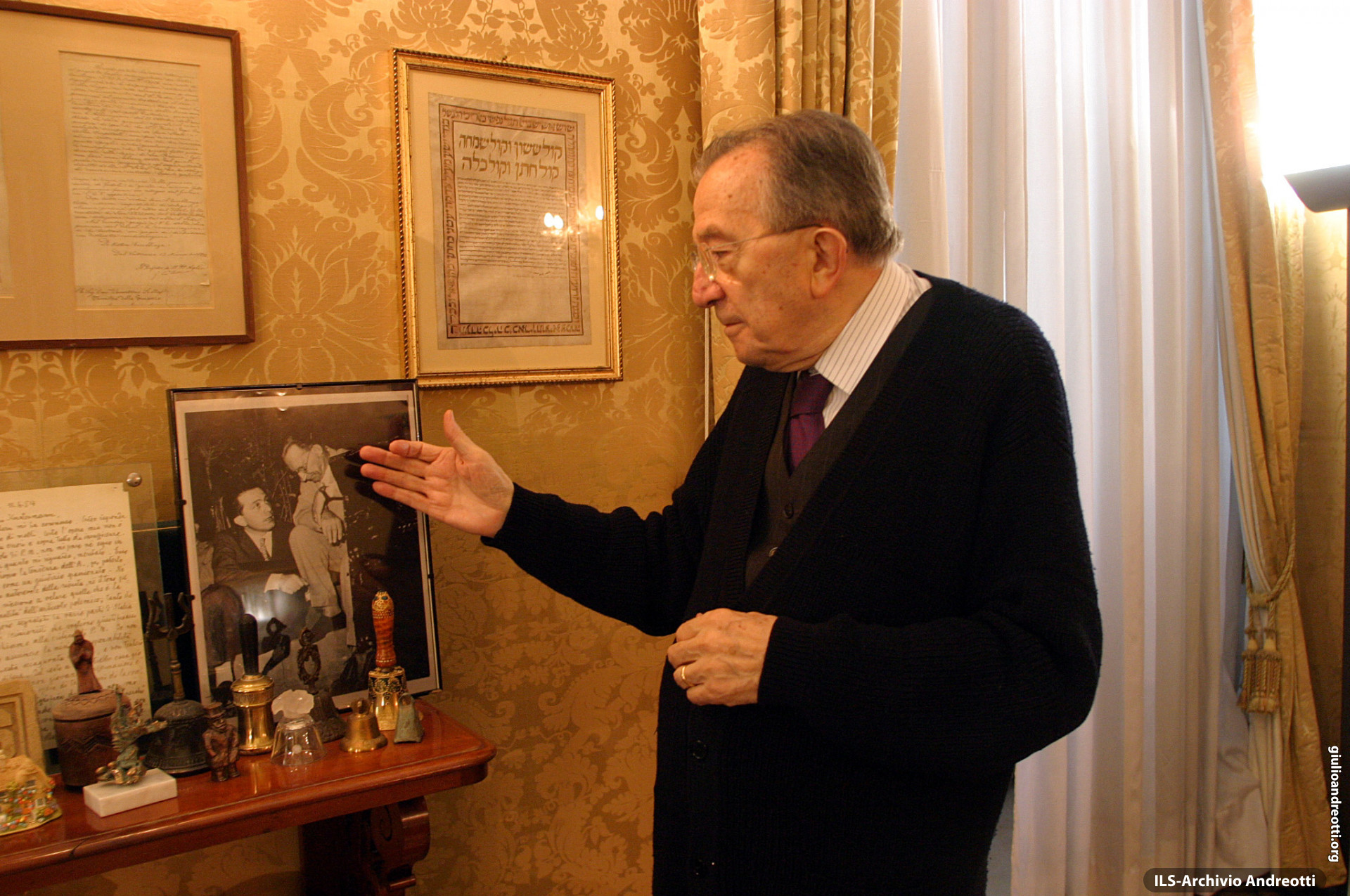 2003. Nel suo studio di Palazzo Giustiniani, il Senatore Andreotti mostra una foto che lo ritrae con il Presidente De Gasperi.